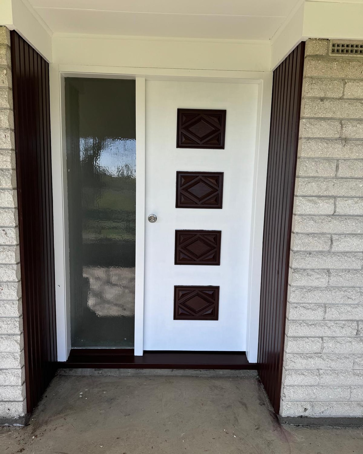 Painter applying fresh coat to door frame during renovation in Auckland