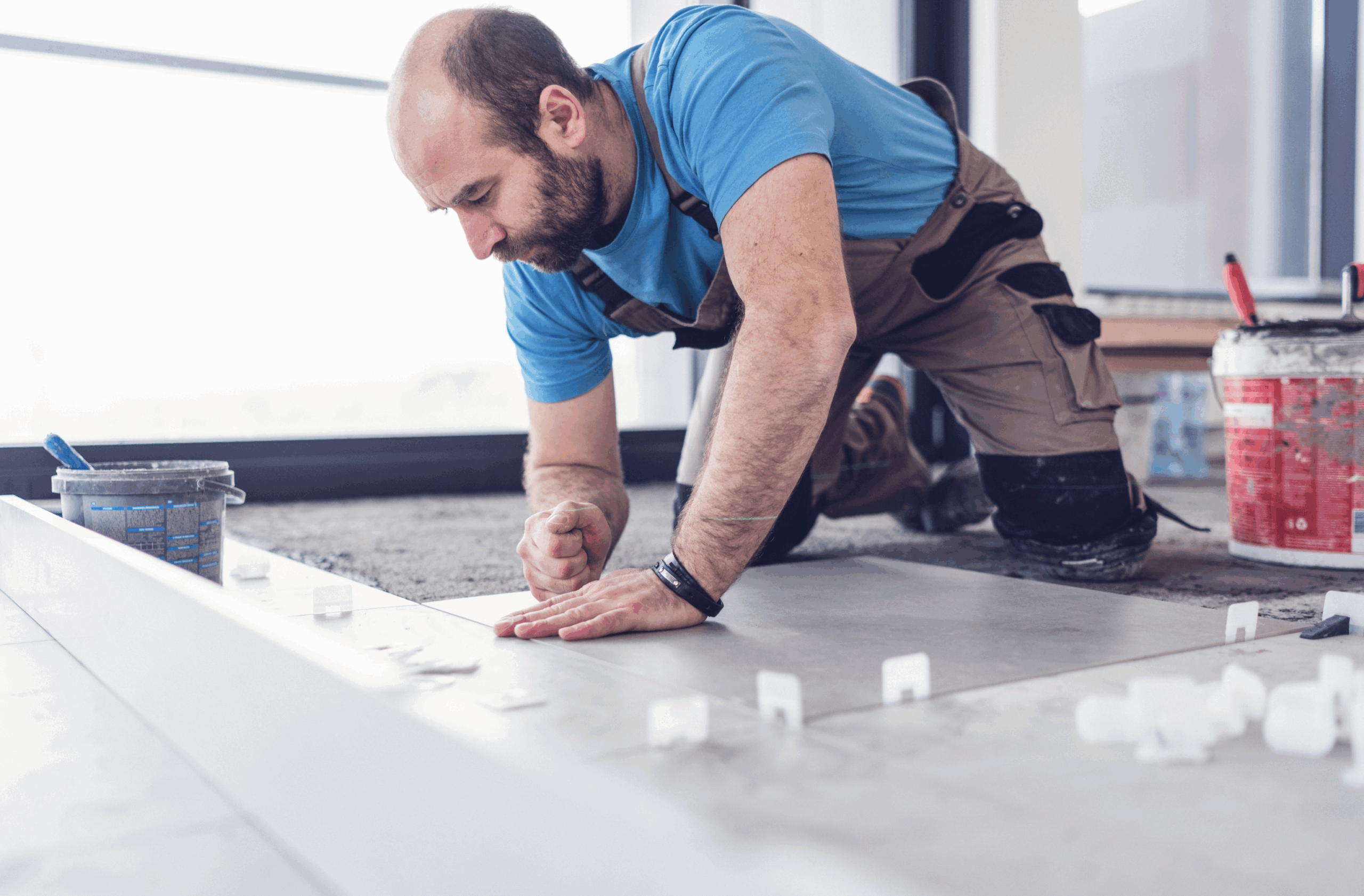 Flooring specialist installing tiles during renovation in Auckland home